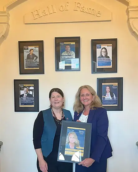 Two alumni with plaque in Hall of Fame